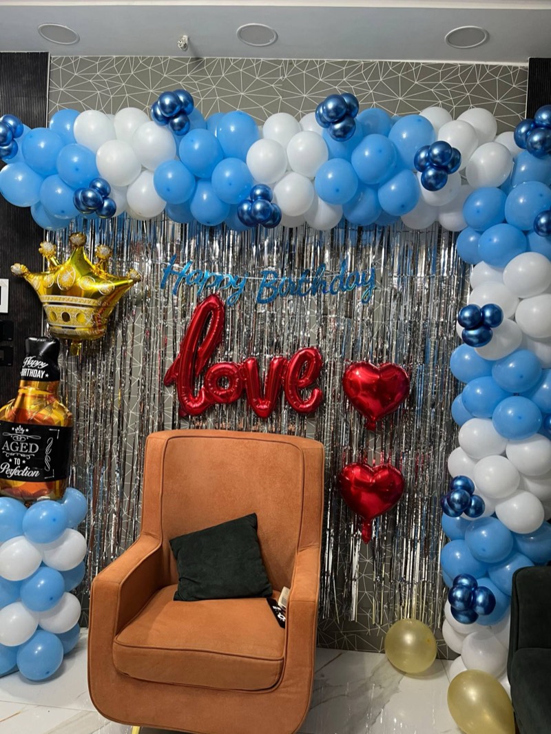 Blue and white balloon garland with a red love foil script, heart balloons and an Aged to Perfection foil bottle