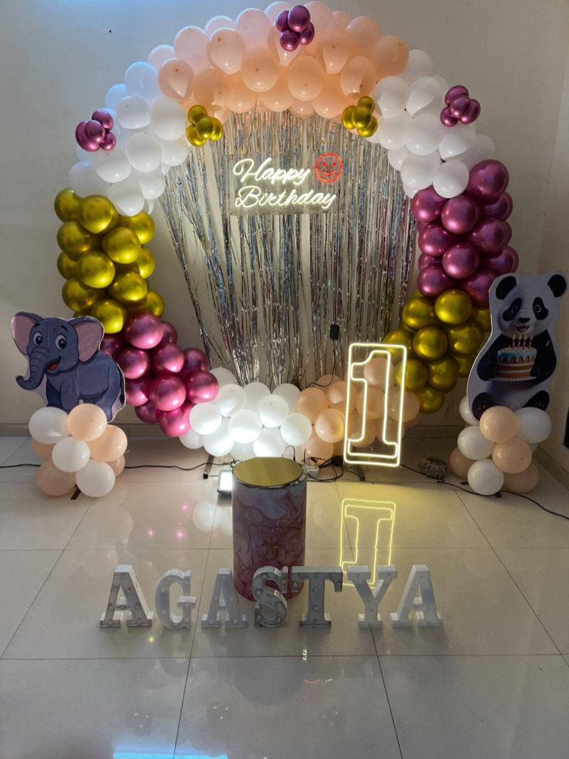 Peach, white, gold and wine balloon arch with elephant and panda cut-outs, neon number one and light-up letters