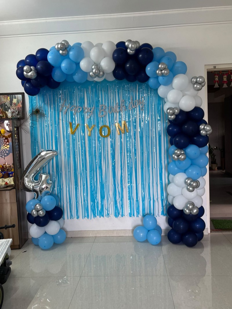 Navy, sky-blue and silver balloon arch beside a silver number four foil balloon